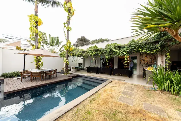Área externa da Casa Palmares com piscina e jardim