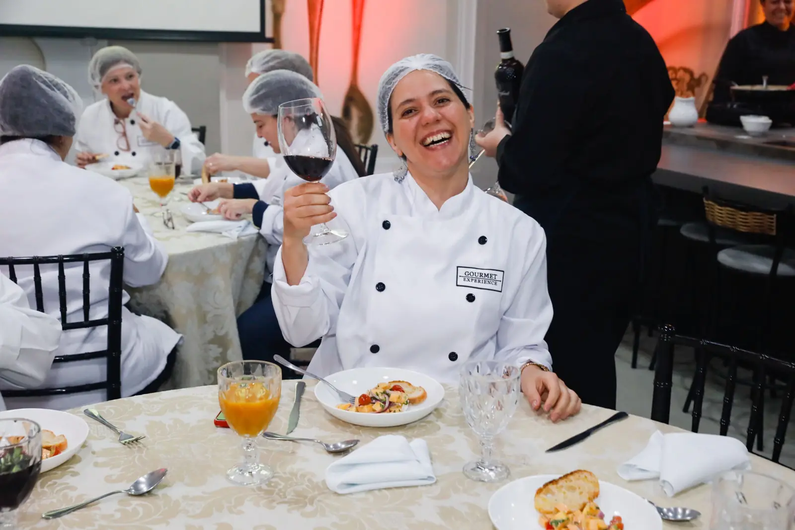 Convidados à mesa, rindo, durante um jantar corporativo na Experience Lounge